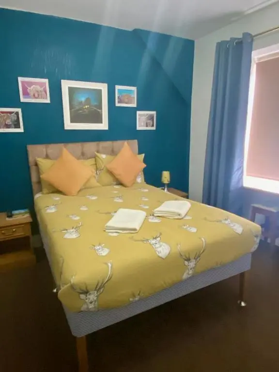 a bedroom with a bed with a yellow comforter at No 29 Bed and Breakfast in Inverness