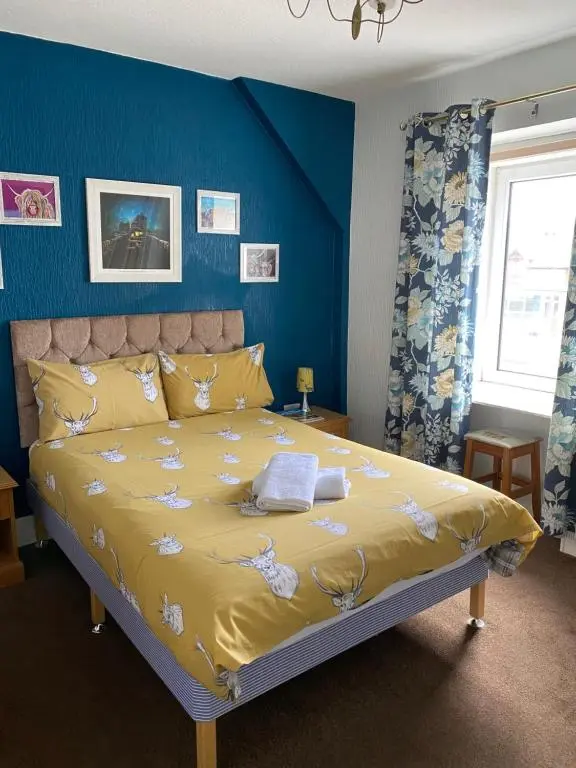 a bedroom with a large yellow bed with blue walls at No 29 Bed and Breakfast in Inverness
