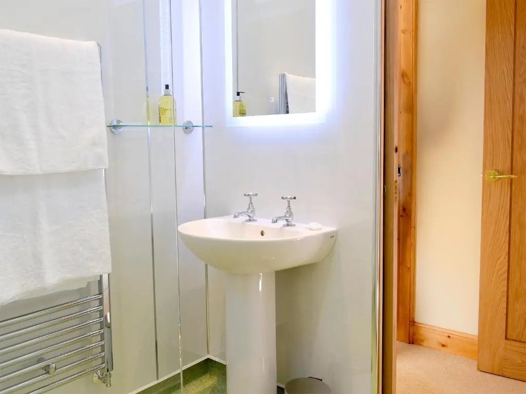 a bathroom with a white sink and a mirror at The Old Inverchroskie Kennels in Enochdhu