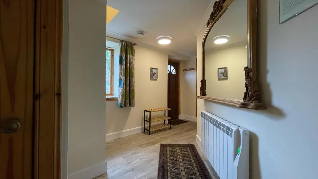 a hallway with a mirror on a wall at Kerrowdown Cottage-Self Catering for 4 in the Highlands in Drumnadrochit