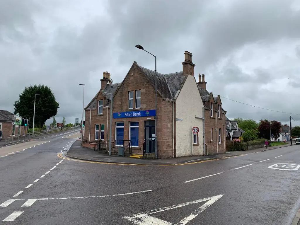 an old building on the side of a street at Muir Bank in Muir of Ord
