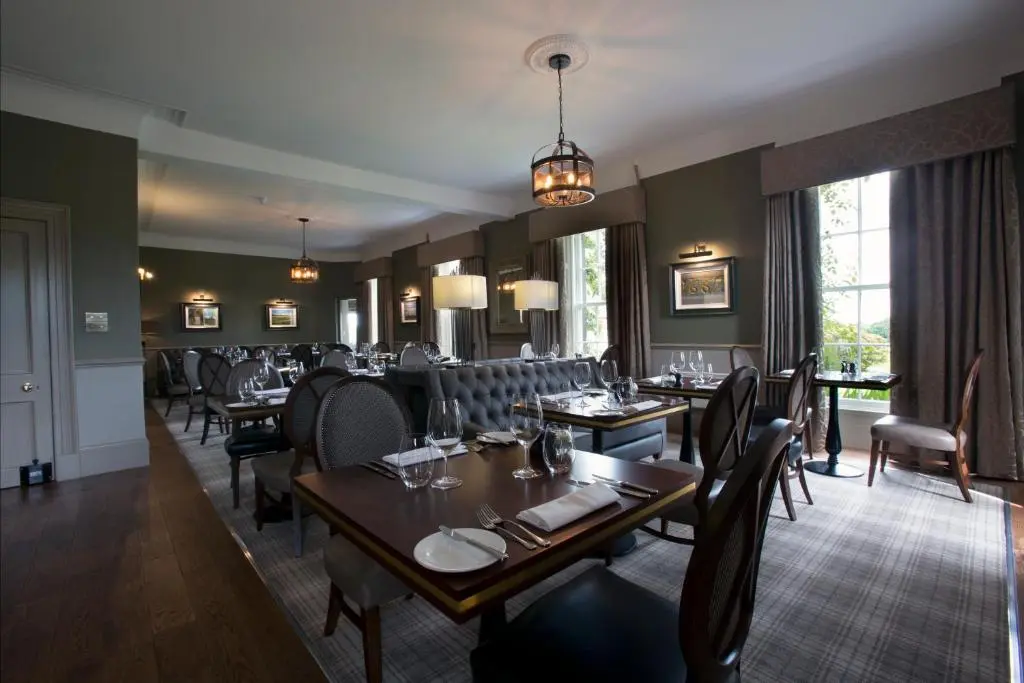 a dining room with tables and chairs in a restaurant at Meldrum House Hotel Golf And Country Estate in Oldmeldrum