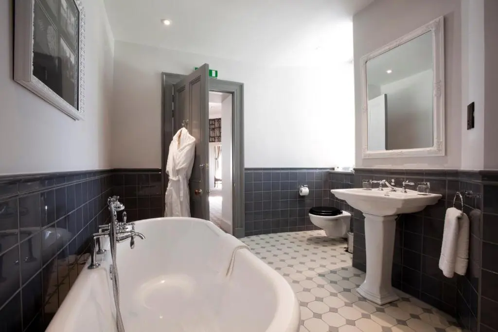 a bathroom with a tub and a sink and a toilet at Meldrum House Hotel Golf And Country Estate in Oldmeldrum