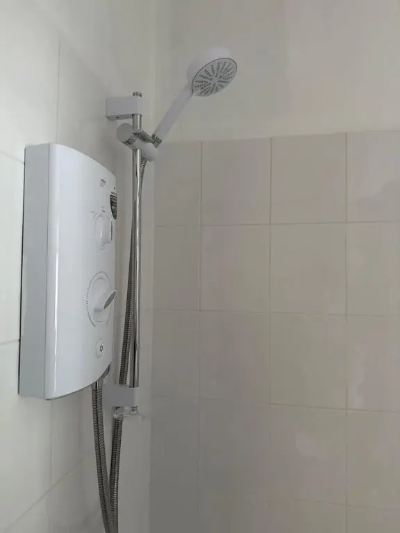 a shower with a shower head in a bathroom at Wimberley House in Inverness