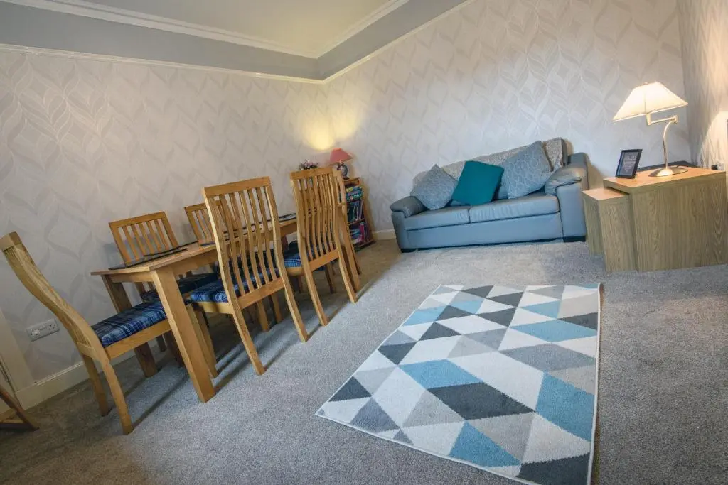 a living room with a couch and a table and chairs at Charming Townhouse on North Coast 500 Route, Wick in Wick