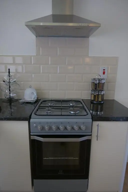 a kitchen with a stove top oven in a kitchen at Kirkside Holiday Home in Alness