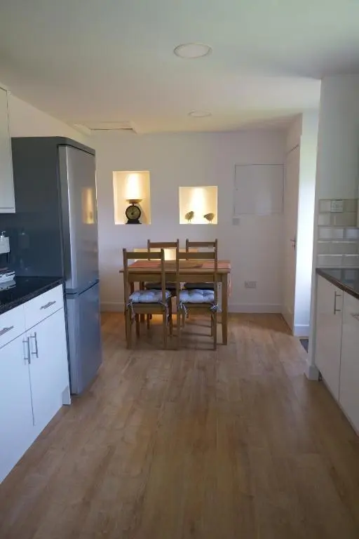 a kitchen and dining room with a table and chairs at Kirkside Holiday Home in Alness