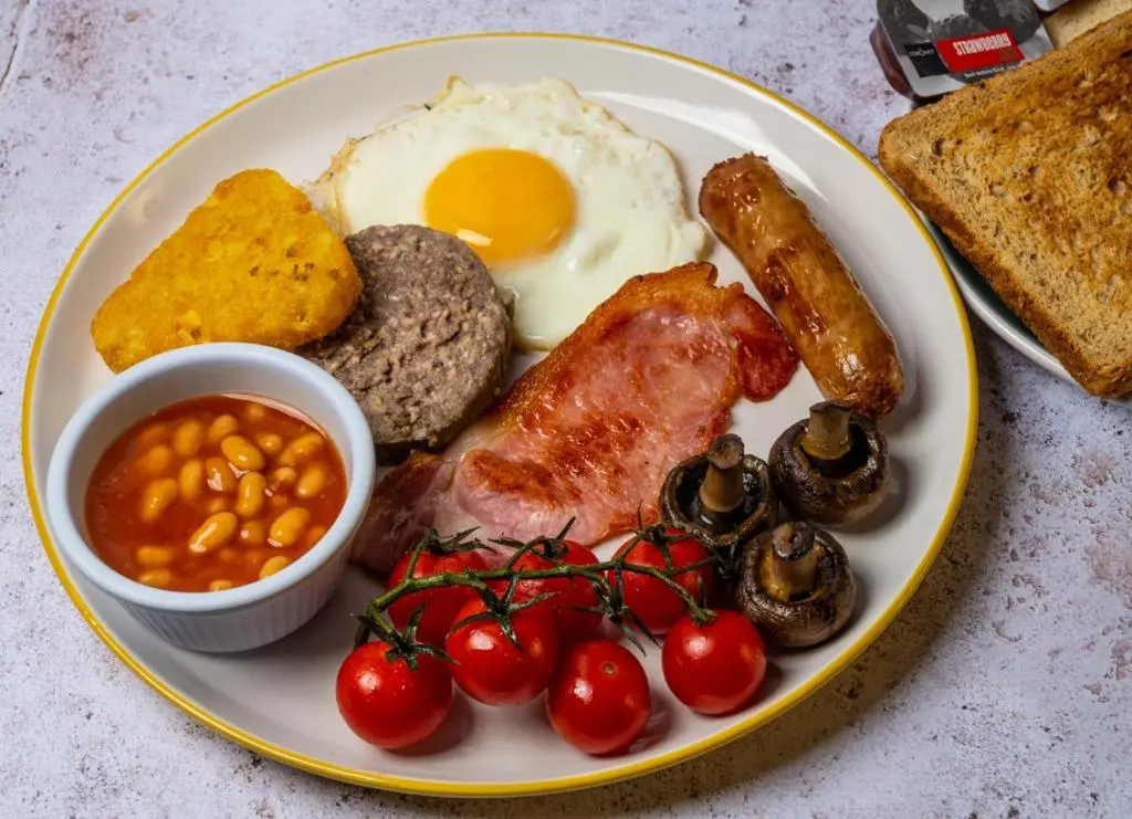 a plate of breakfast food with eggs sausage beans and bread at Pinehurst Lodge Hotel -Dyce, Aberdeen in Dyce