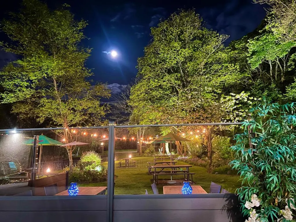 a garden at night with a picnic table and lights at Pinehurst Lodge Hotel -Dyce, Aberdeen in Dyce