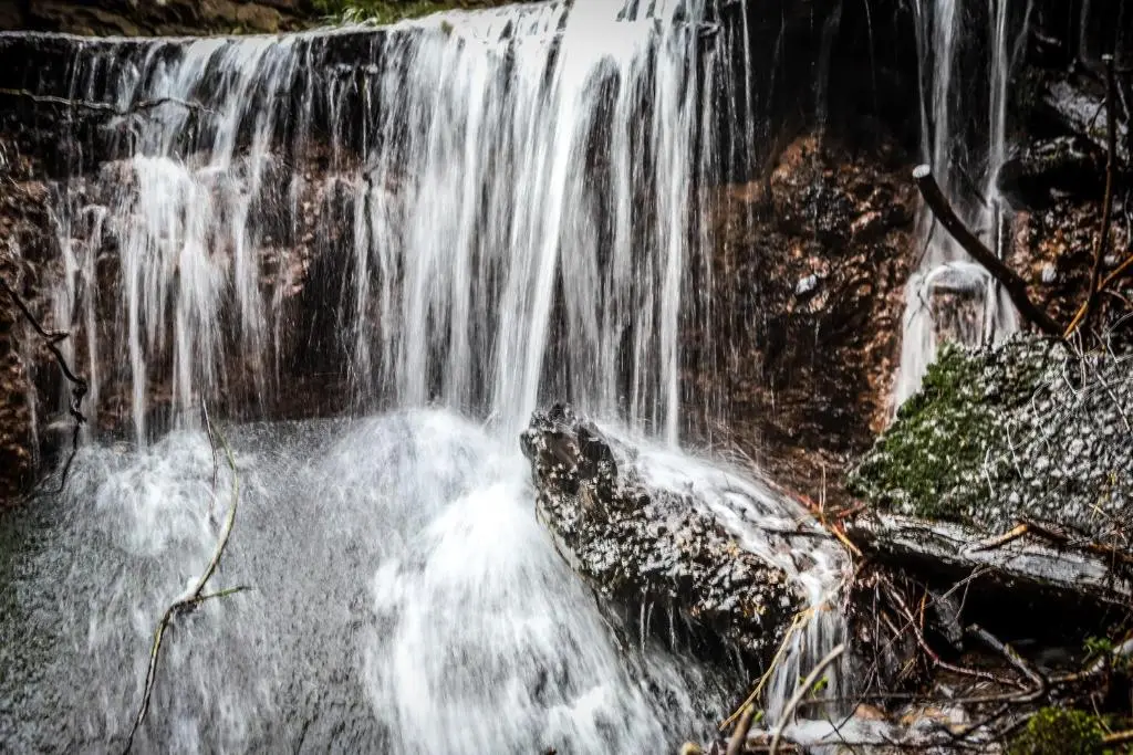 a waterfall in the middle of a forest at A UNIQUE Experience in a Converted Shipping Containers, Glamness is Adults Only in Inverness