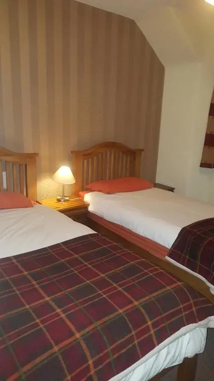 two beds sitting next to each other in a room at Ord Arms Hotel in Muir of Ord