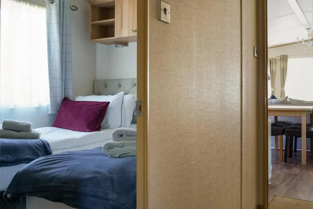 a bedroom with a bed and a room with a table at Ruapehu Lodge in Aviemore
