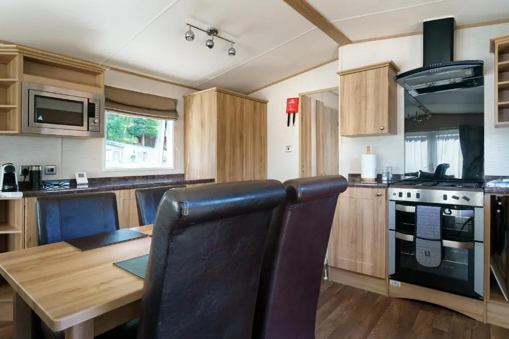 a kitchen with a wooden table and a dining room at Ruapehu Lodge in Aviemore