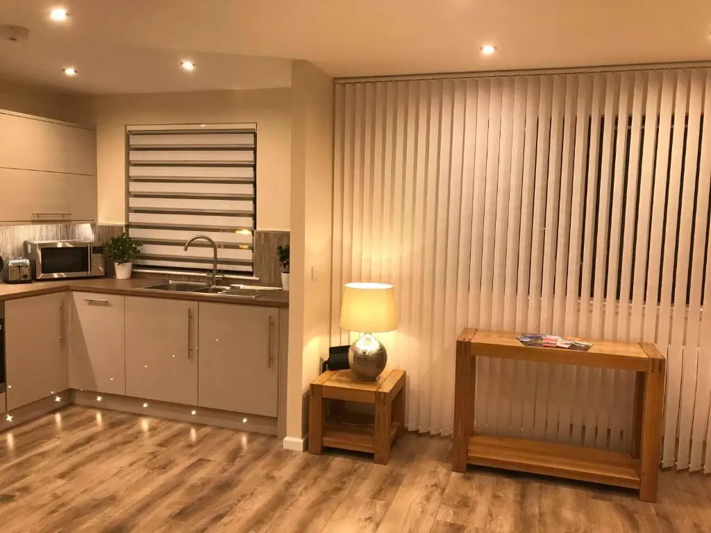 a kitchen with a table and a lamp on a table at exploreNESS Apartment in Inverness