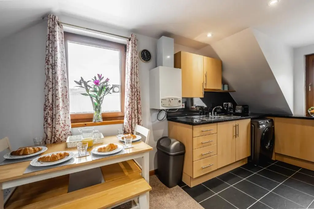 a kitchen with a sink and a table with food on it at Aldo's Place in Dingwall