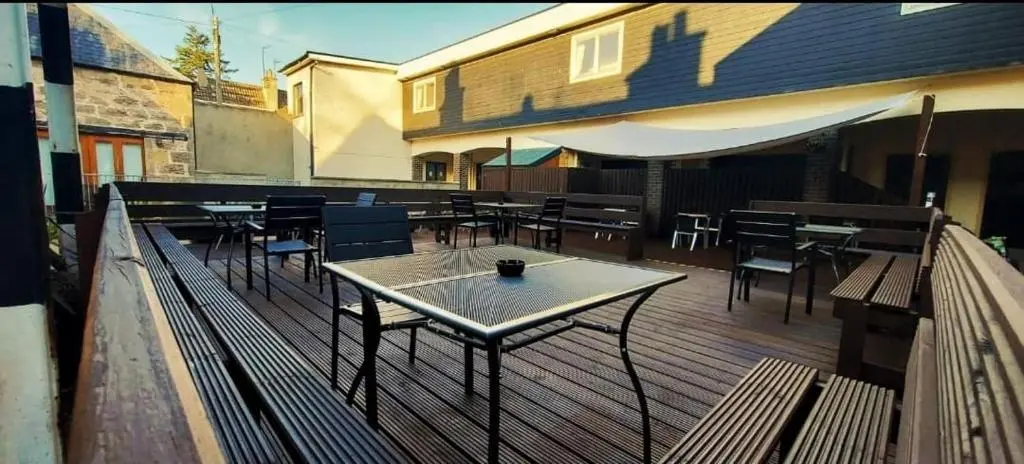a patio with tables and chairs on a deck at Gordon Arms Hotel in Fochabers