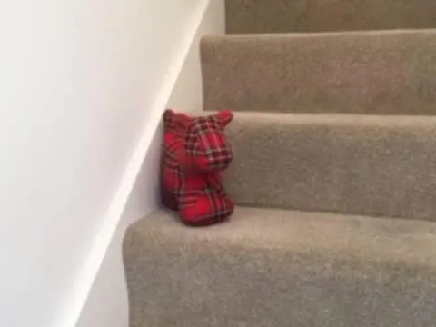 a red tie sitting on the side of some stairs at Number 5, Muirfield Court in Inverness