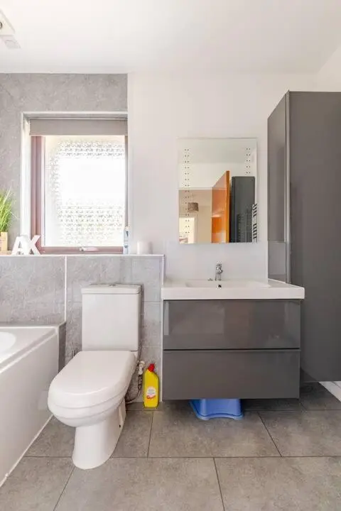 a bathroom with a toilet and a sink and a mirror at Number 5, Muirfield Court in Inverness