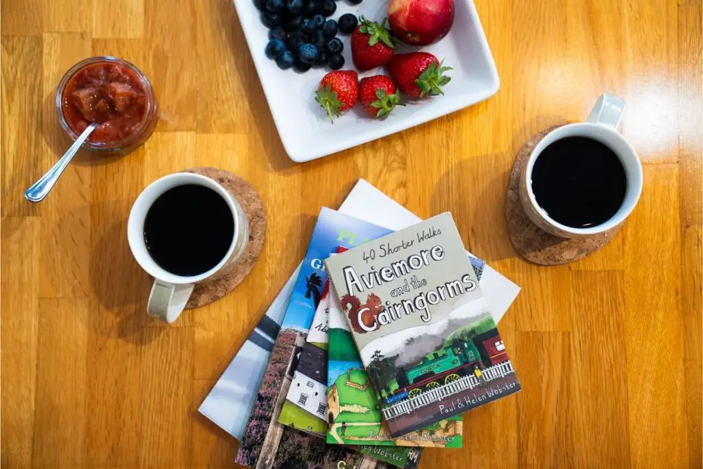 a table with two cups of coffee and a plate of fruit at Courtyard Bothy in Grantown on Spey