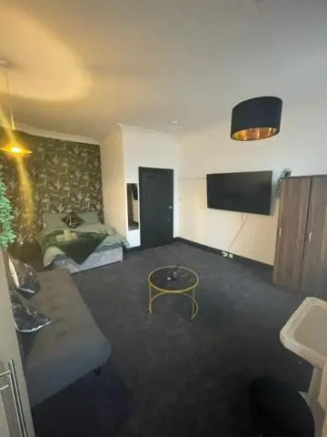 a living room with a couch and a television at Carlton Hotel in Forres