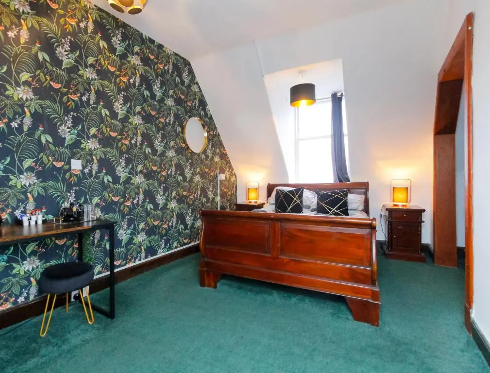 a bedroom with a bed and a desk and a window at Carlton Hotel in Forres