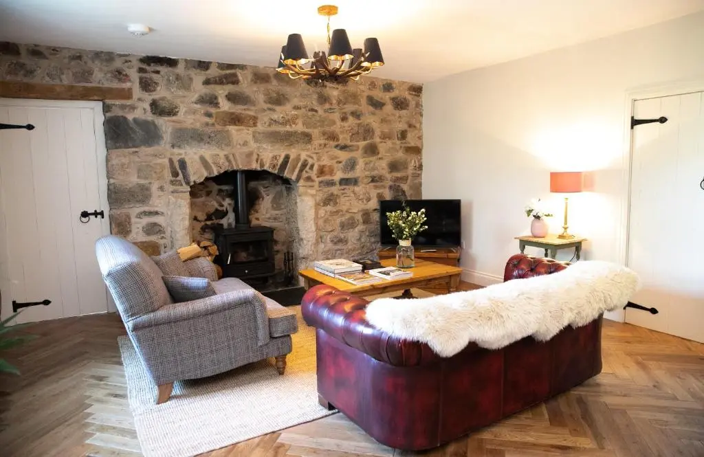 a living room with a couch and a fireplace at Dandaleith Cottage No.1 in Craigellachie