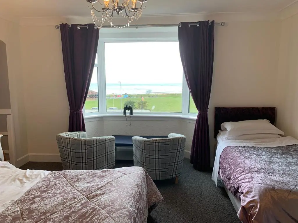 a bedroom with two beds and a large window at "Stunning Sea-Views" at Wetherby Nairn in Nairn