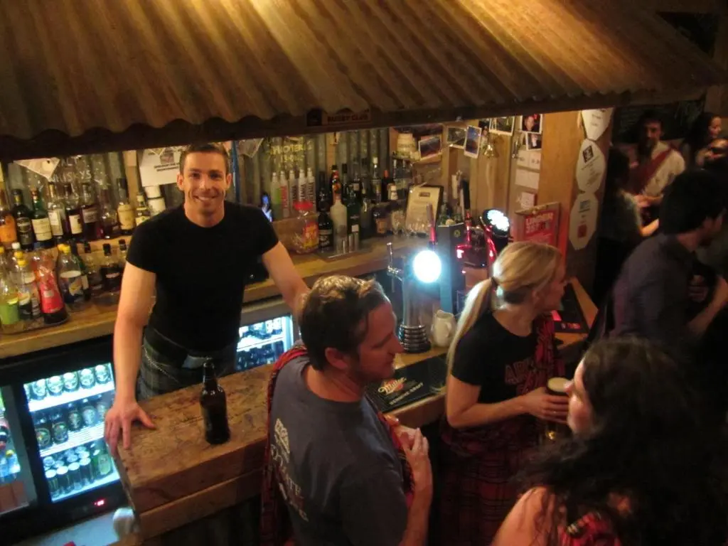 a group of people standing at a bar at Morag's Lodge in Fort Augustus