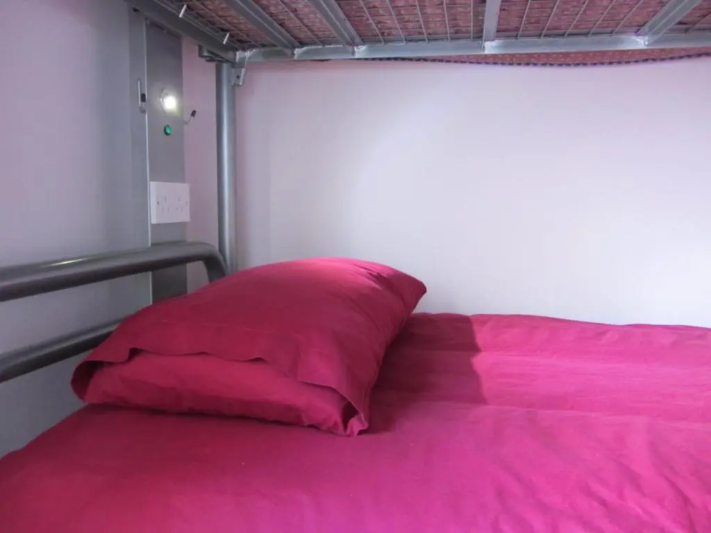a pink pillow sitting on top of a bed at Morag's Lodge in Fort Augustus