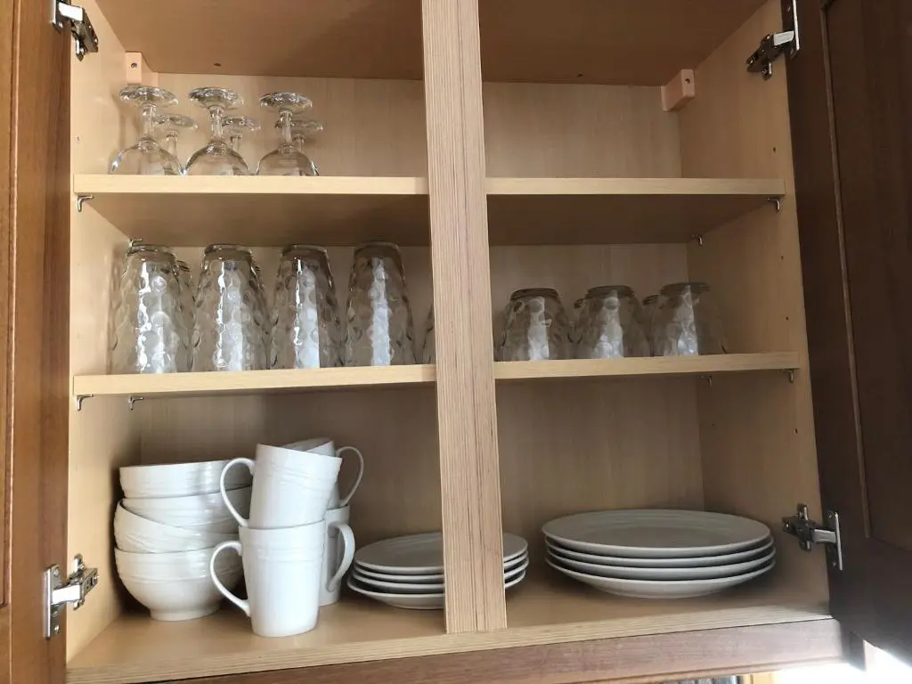 a cabinet filled with plates and cups and dishes at BORD DE L\u2019EAU APARTMENT in Wick