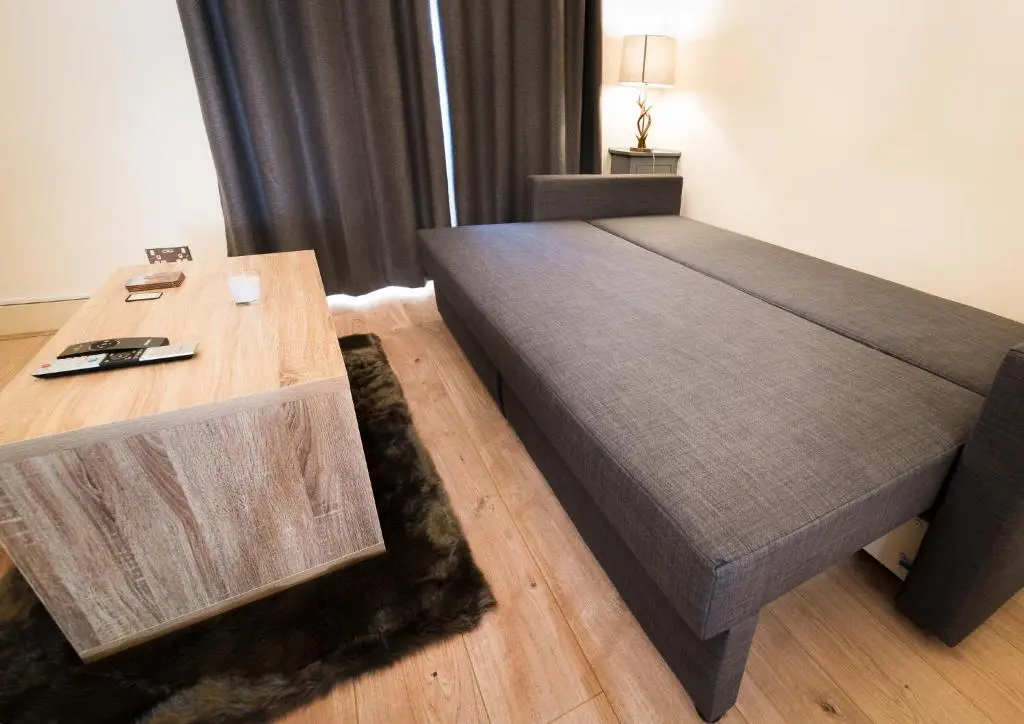 a bedroom with a large bed and a wooden table at STAG City Centre apartment in Inverness