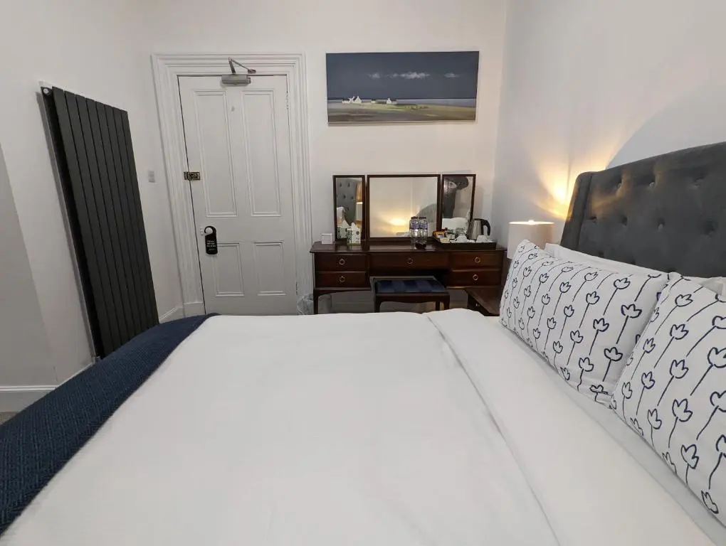 a bedroom with a white bed and a desk at Cambeth Lodge Guesthouse in Inverness