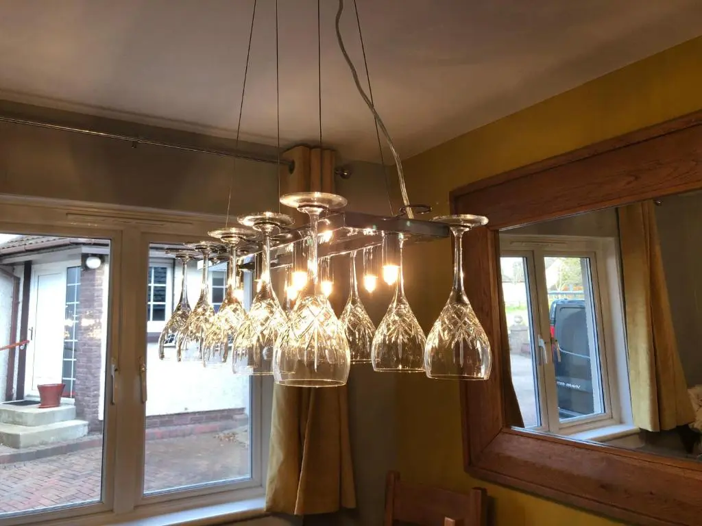 a chandelier with wine glasses hanging from a ceiling at Linmore in Aviemore