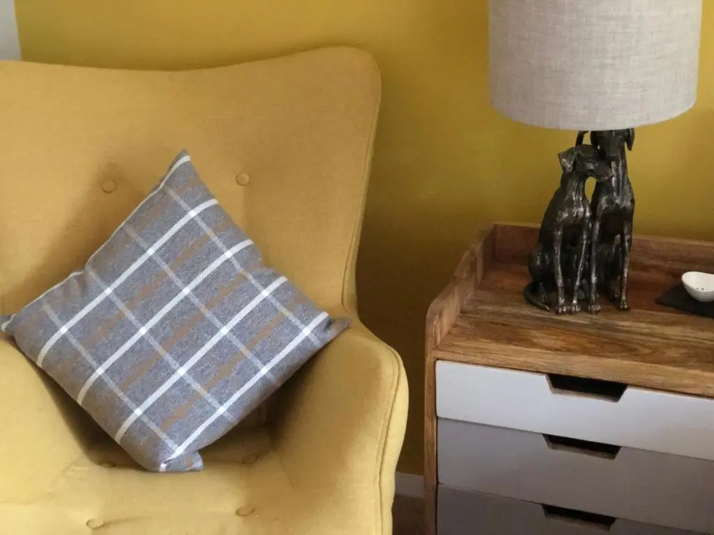 a pillow sitting on a chair next to a table at Linmore in Aviemore