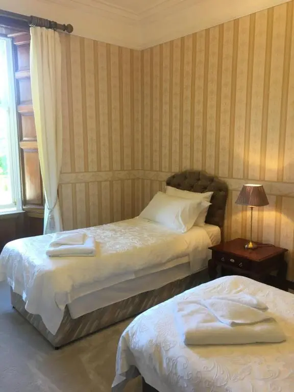a bedroom with two beds and a window at Ledgowan Lodge Hotel in Achnasheen