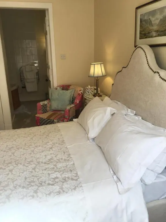 a bed with white sheets and pillows in a bedroom at Ledgowan Lodge Hotel in Achnasheen