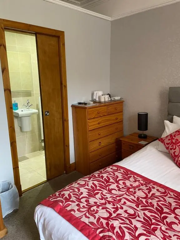 a bedroom with a bed and a bathroom with a sink at Inchrye Bed & Breakfast in Inverness