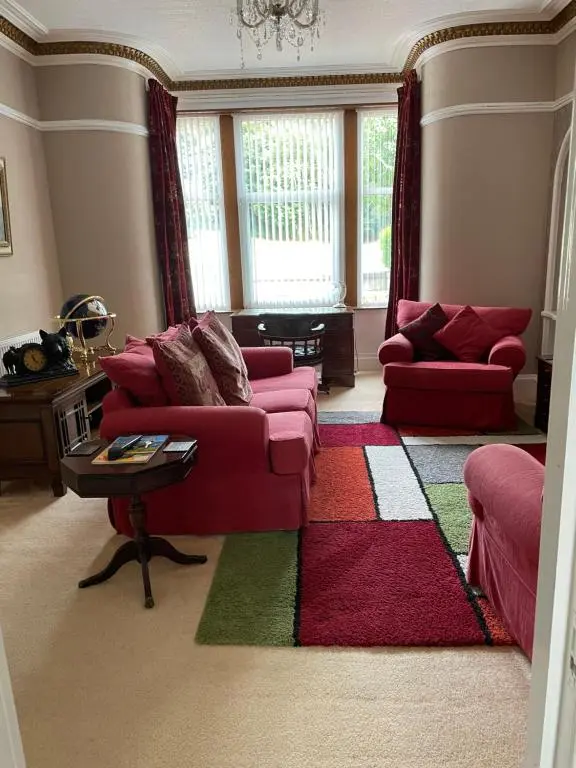 a living room with a pink couch and a rug at Inchrye Bed & Breakfast in Inverness