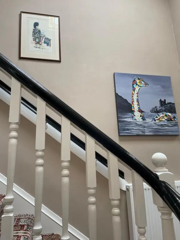 a staircase with two pictures of a dog on the wall at Inchrye Bed & Breakfast in Inverness