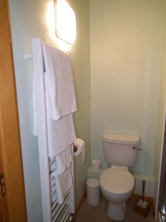 a bathroom with a white toilet and towels at The Red Lion Tavern in Fochabers