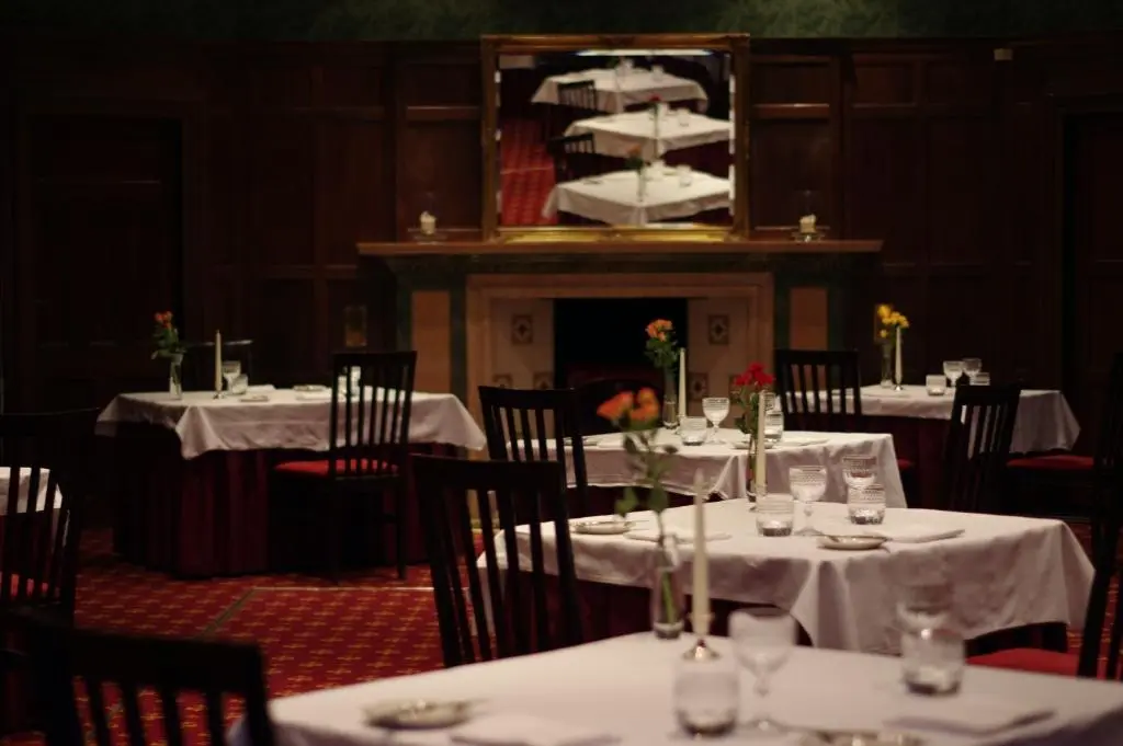 a dining room with tables and chairs with a cake on top at Bunchrew House Hotel in Inverness
