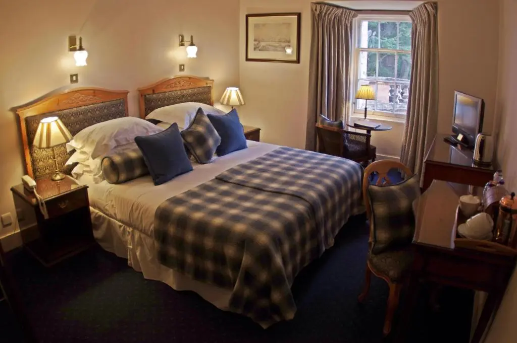 a hotel room with a bed and a window at Bunchrew House Hotel in Inverness