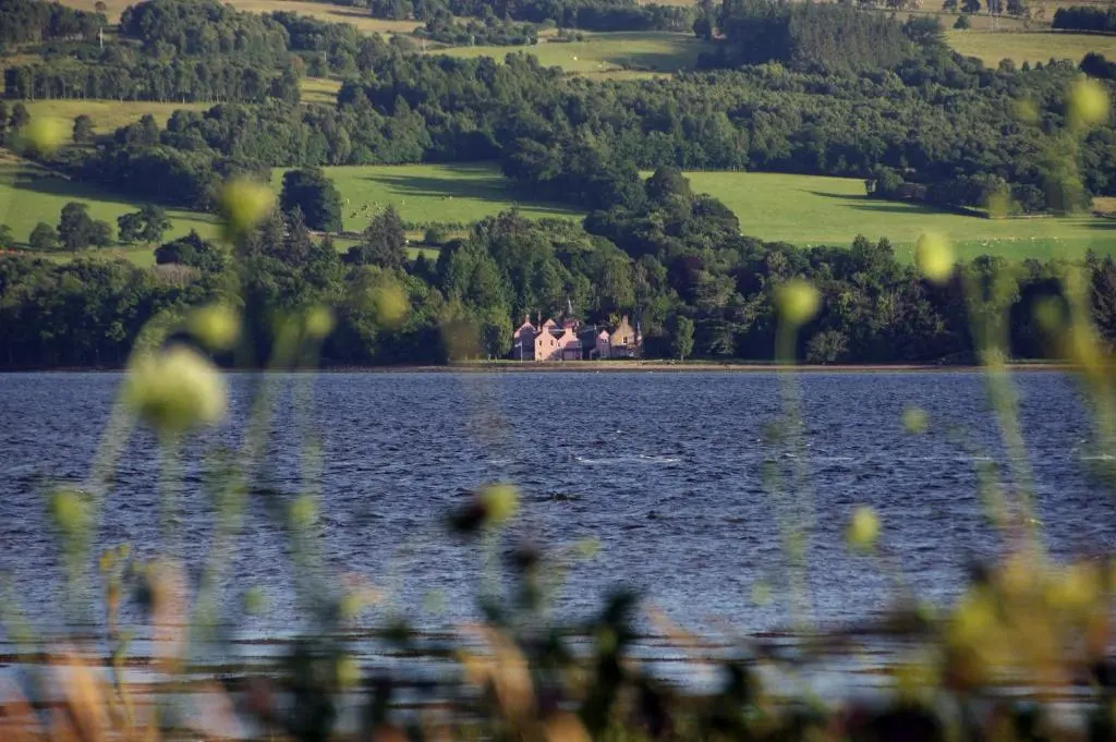 a view of a lake with a house in the distance at Bunchrew House Hotel in Inverness
