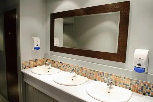 a bathroom with two sinks and a mirror at Chieftain Hotel in Inverness