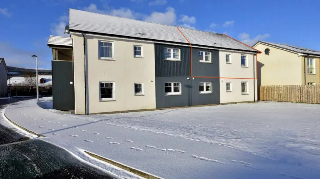 a house with footprints in the snow next to a street at Stelvio in Aviemore