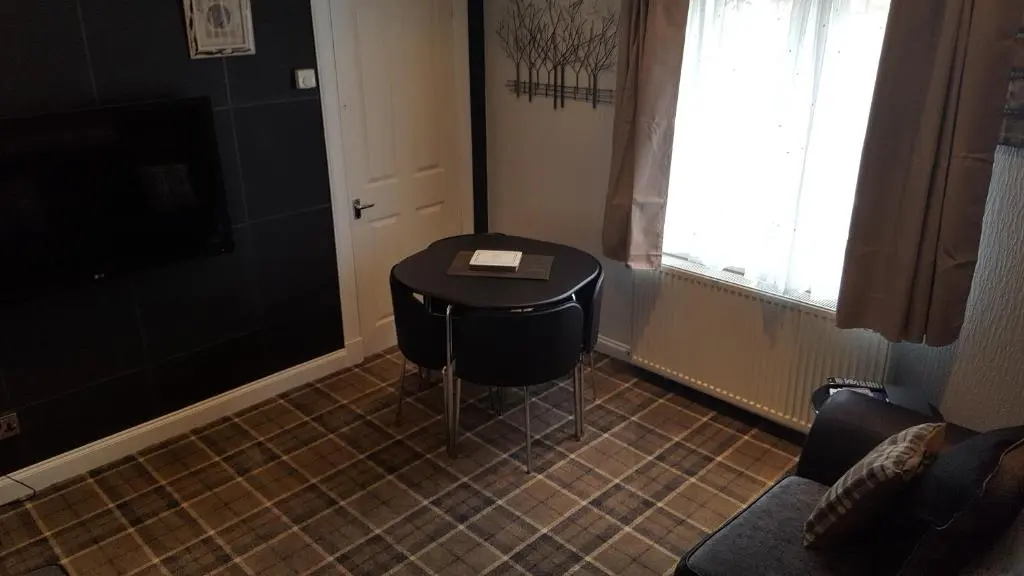 a small table in a room with a window at Pitfaranne Guest House in Inverness