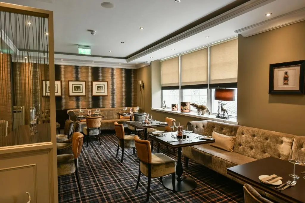 a restaurant with a couch and tables and chairs at The Seafield Arms-Cullen in Cullen