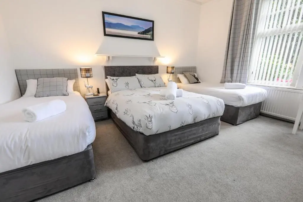 a bedroom with two beds and a tv on the wall at Aye Stay in Inverness