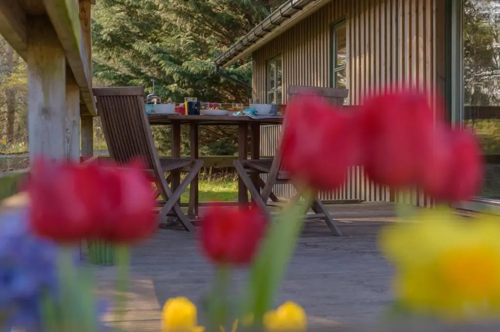 two chairs and a table with flowers on a patio at Ben Macdui in Banchory