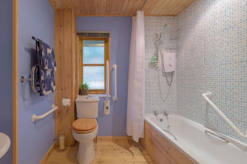 a bathroom with a toilet and a tub and a sink at Ben Macdui in Banchory